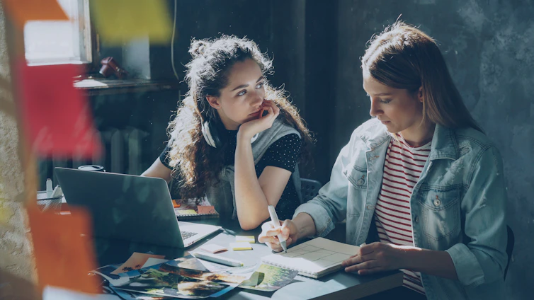 Two women are working together on a project.