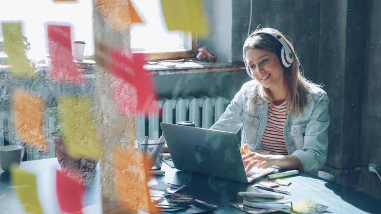 A woman works happily on her laptop.