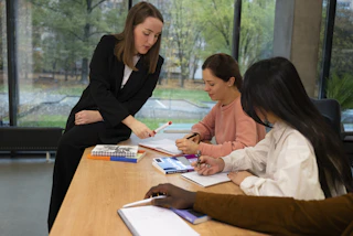 A woman is guiding people in a meeting.
