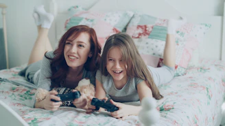 A mother and daughter play video games together.