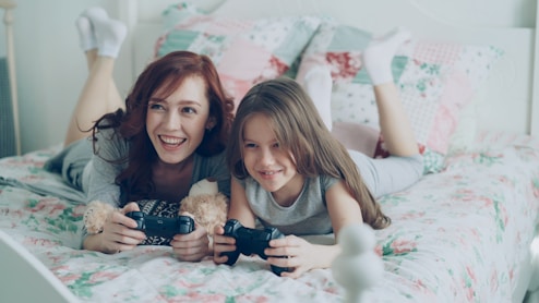 A woman and a child happily play video games.