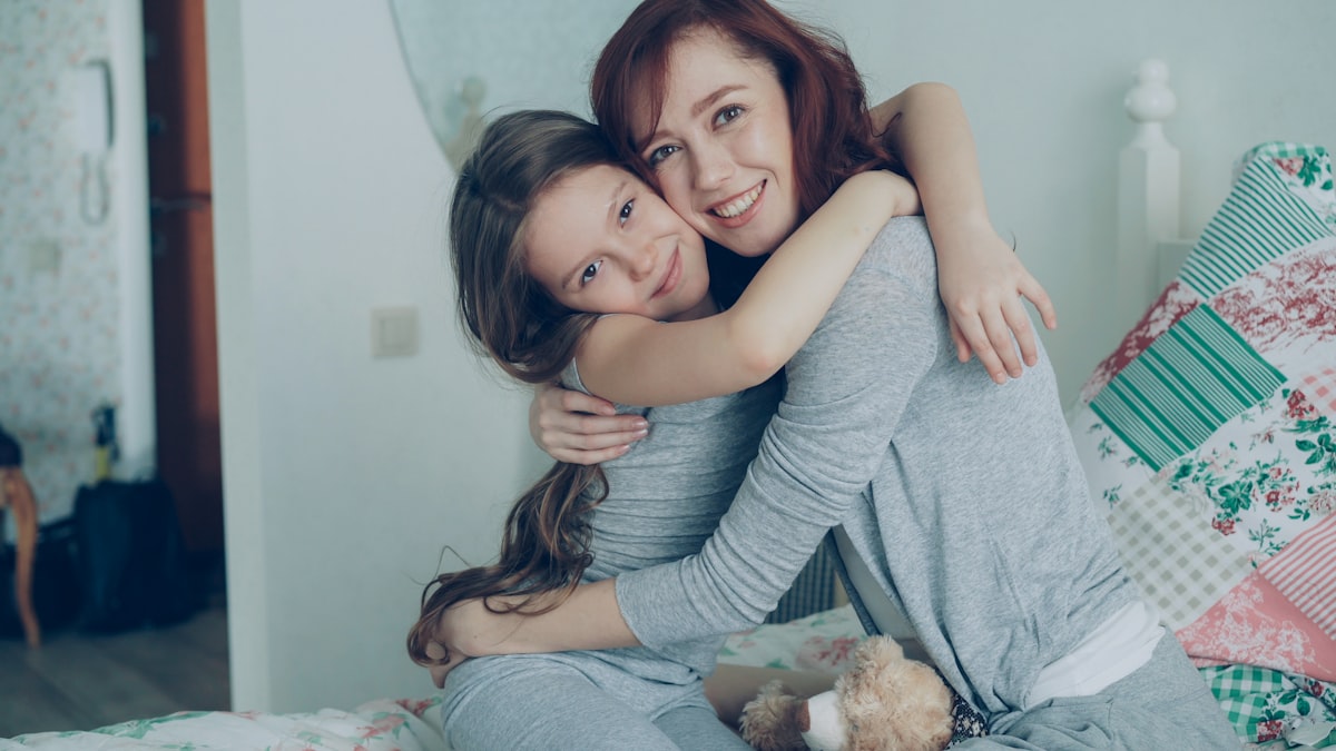 Mom hugging her daughter warmly