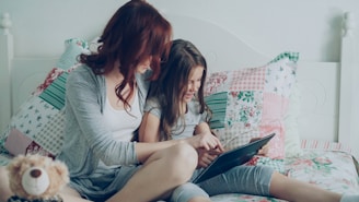 Mom and daughter read on a tablet together.