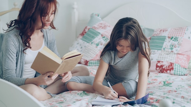 Mom helps her daughter with her homework.