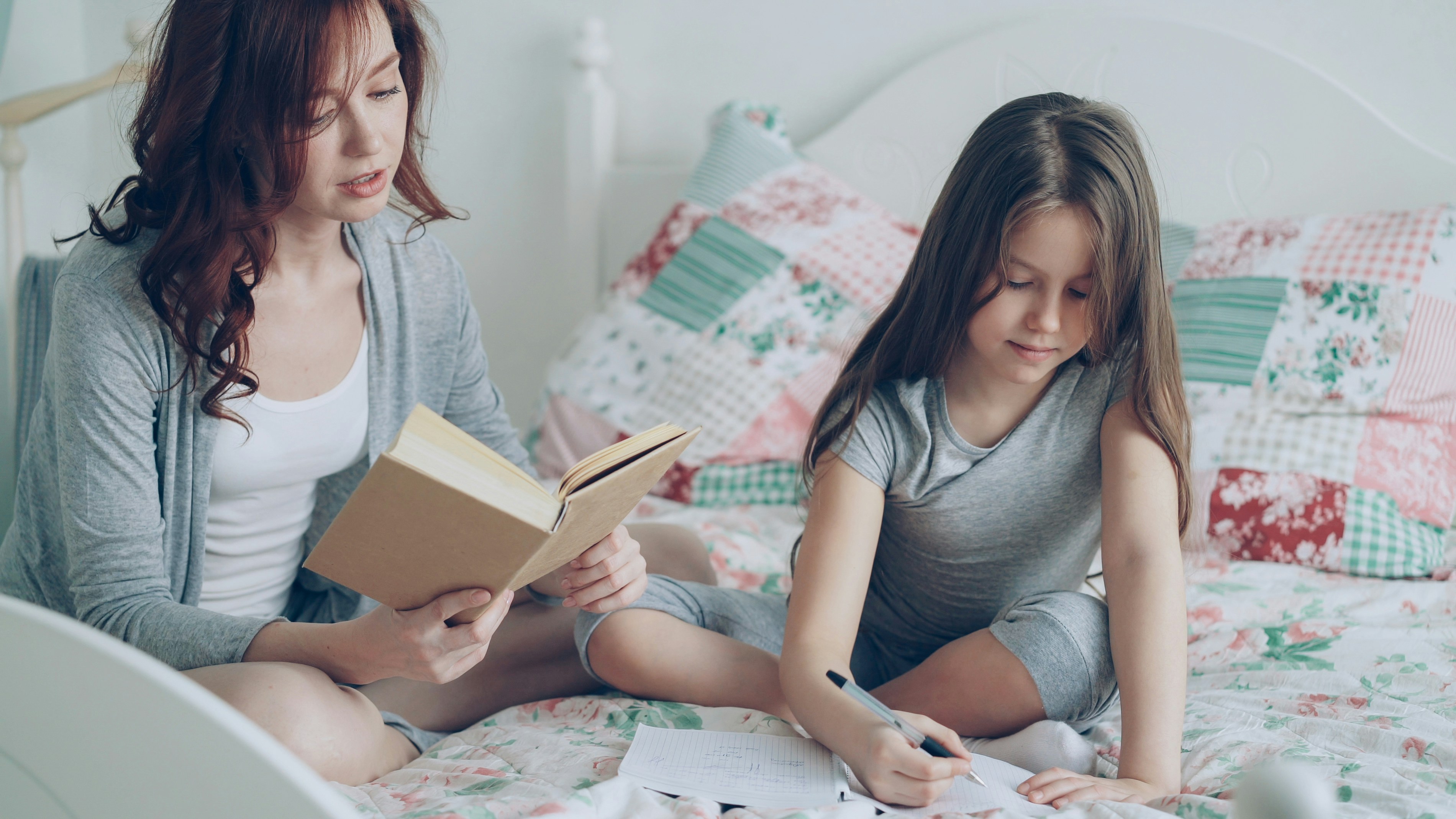 Young mother helping daughter with homework