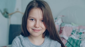 A young girl smiles directly at the camera.