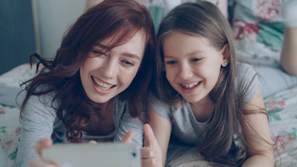 Two girls smile while taking a selfie
