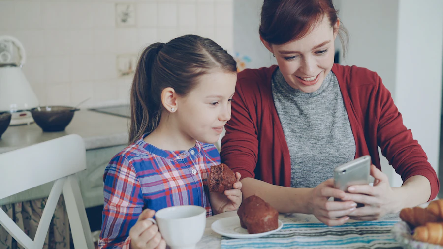 A mother and daughter looking at a phone together