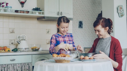 Mother and daughter baking happily in the kitchen.