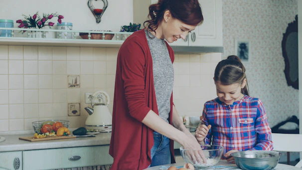 Mother and daughter are baking together in the kitchen
