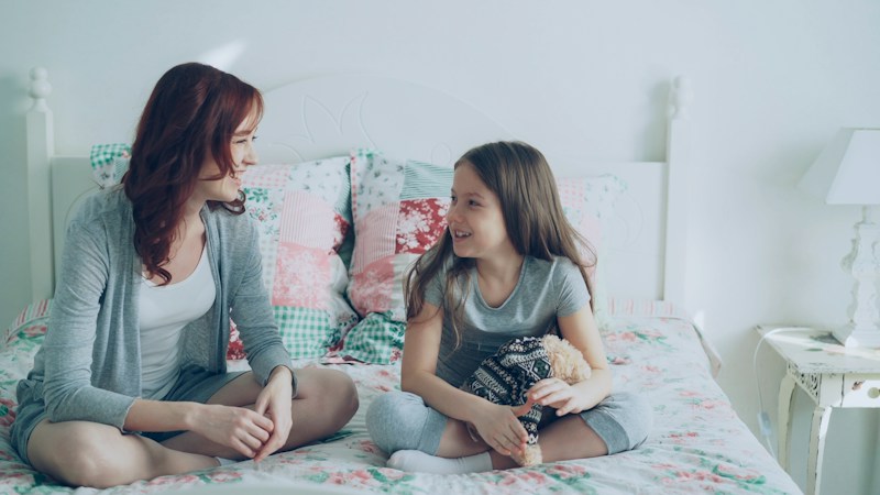 A mother and her young daughter having a calm conversation at home, the kind of talk parents can have about school safety