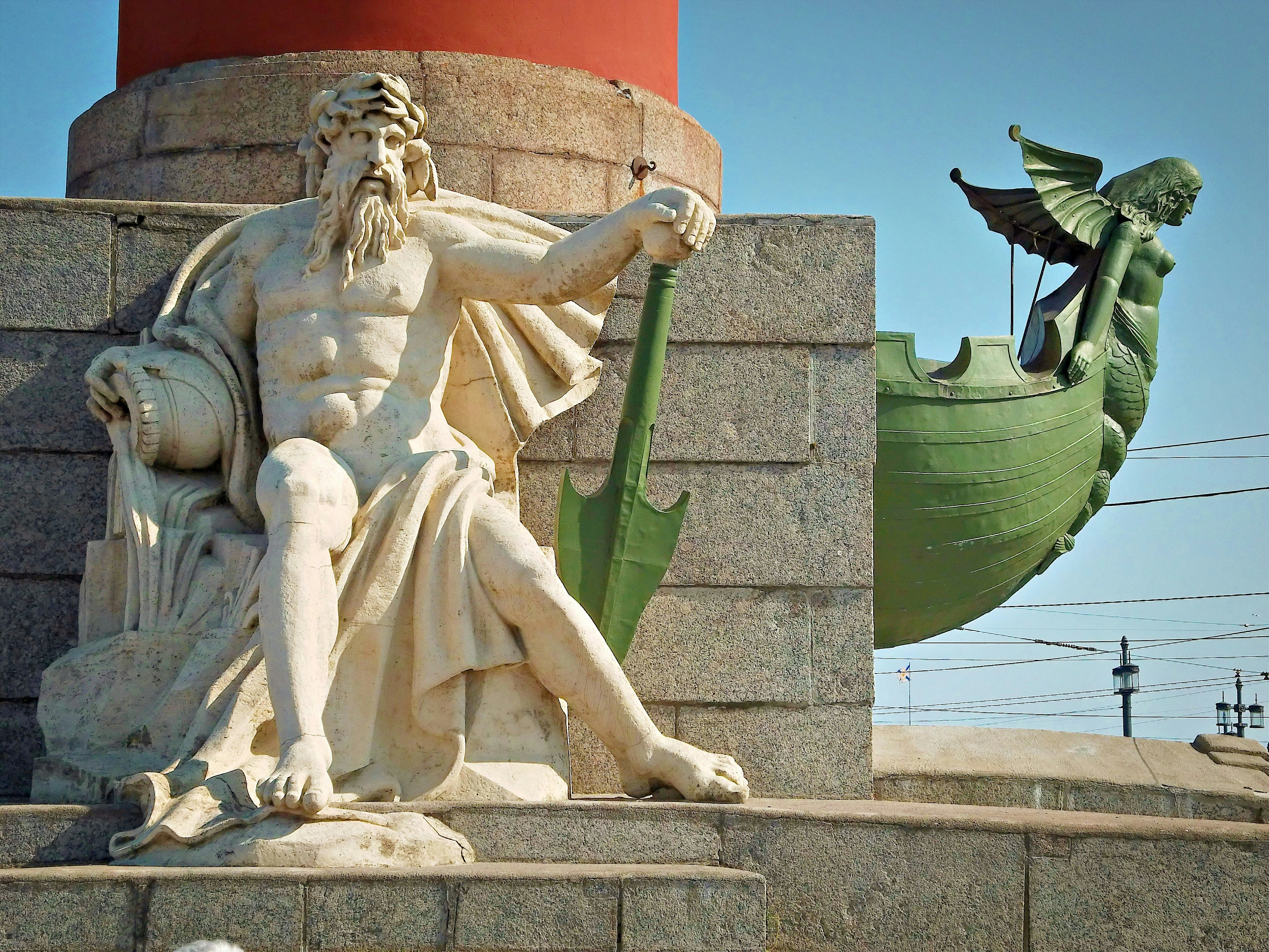 A statue of poseidon and a ship.