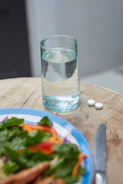 Water and pills with a healthy meal.