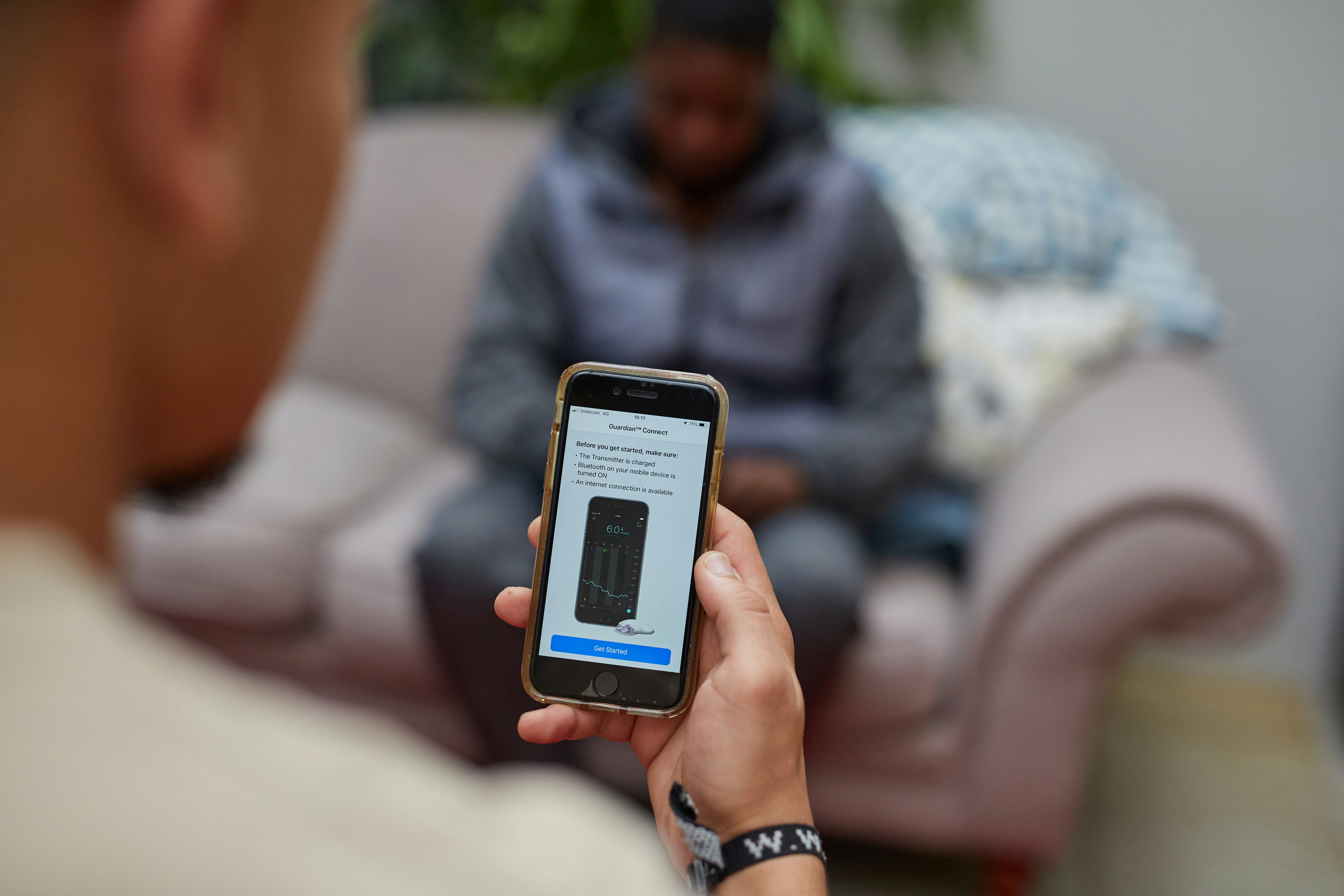 A person is showing someone a smartphone
