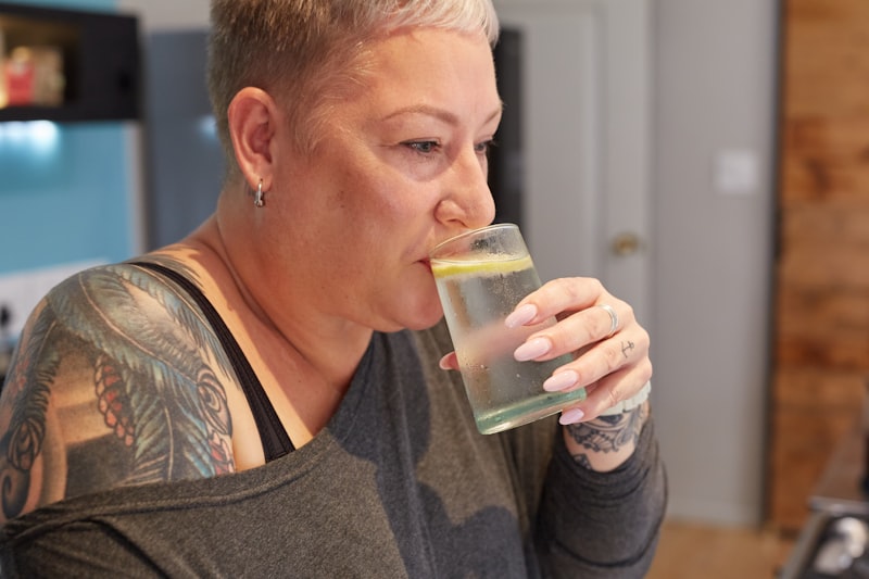 Older woman enjoying a healthy drink, smiling in a bright kitchen