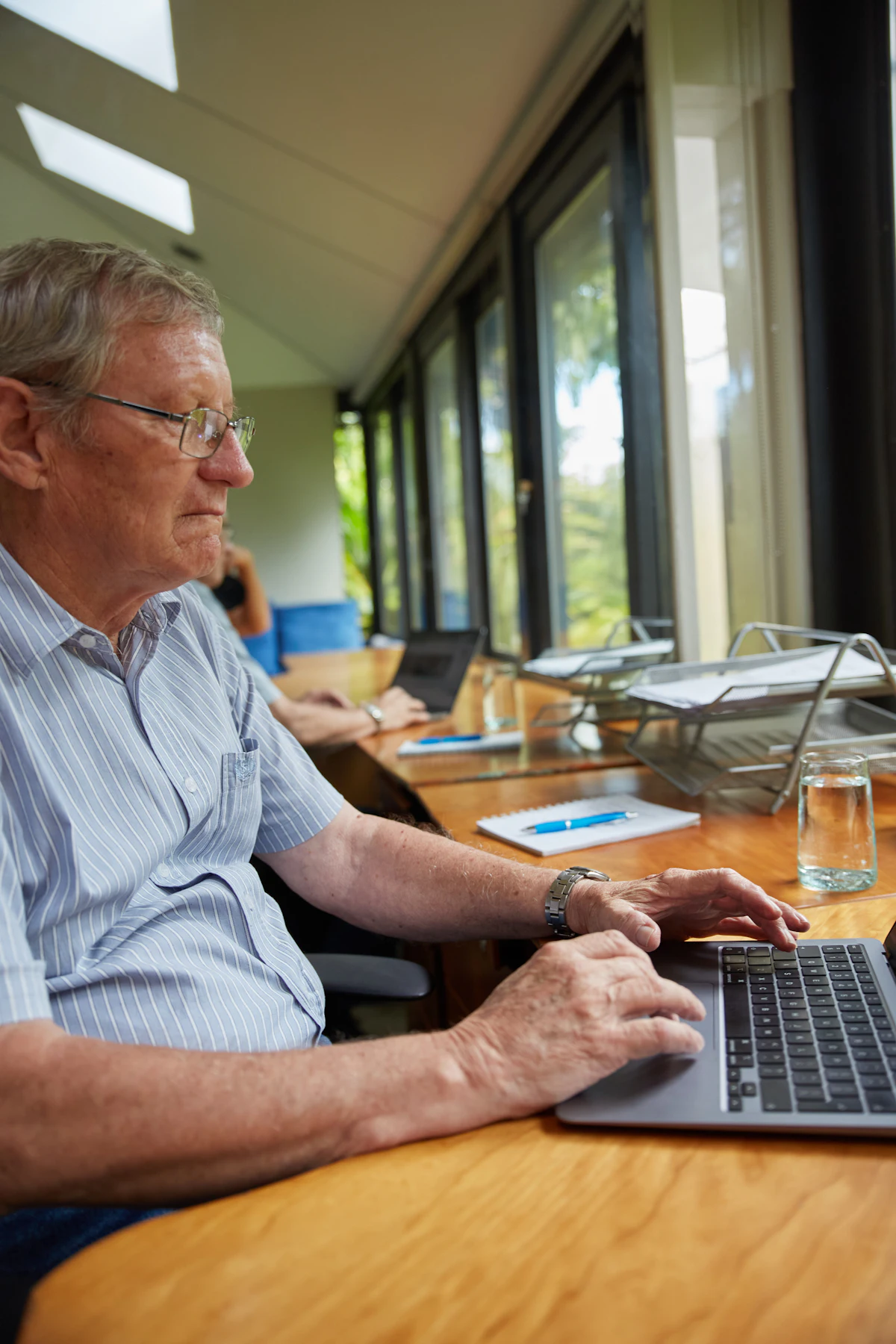 An older man working on a laptop at a desk