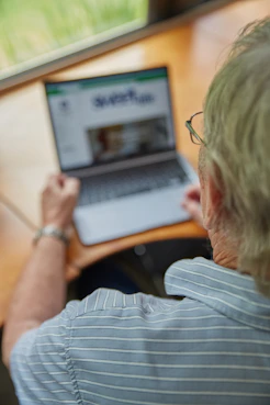 An elderly person is using a laptop