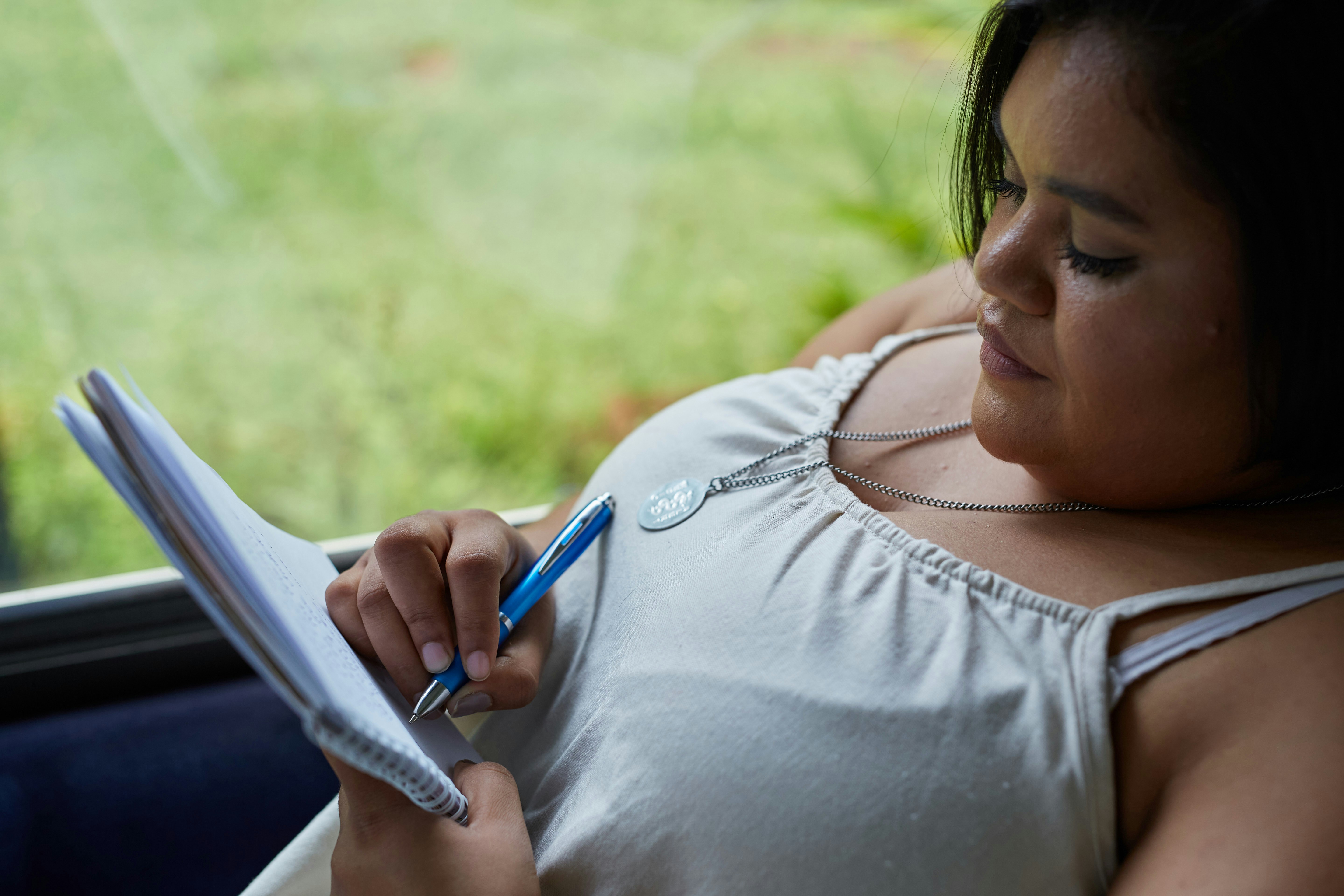 A woman writing in a fitness journal, tracking her workouts and progress - womens health and fitness