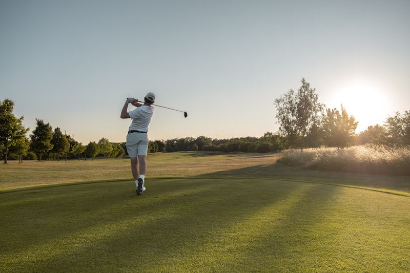 Golfer swinging on a sunny open course