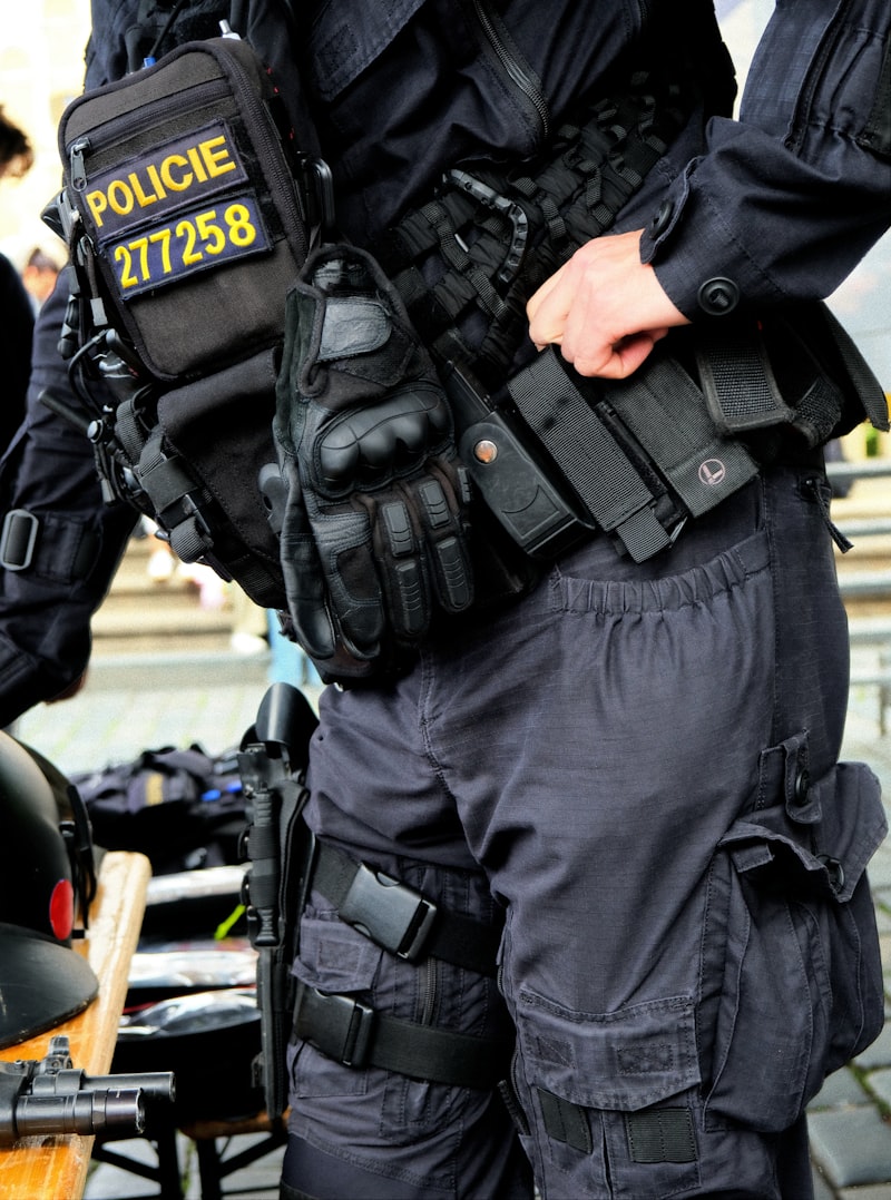 Tactical police officer in dark uniform with weapon holster and gear