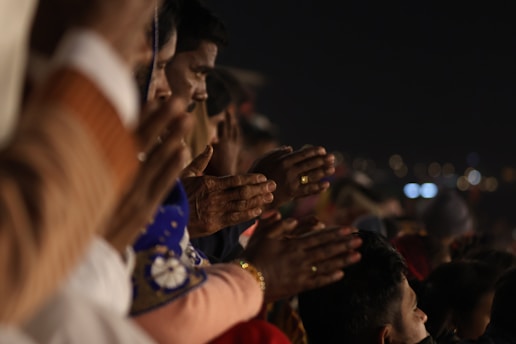 People pray together, hands clasped.