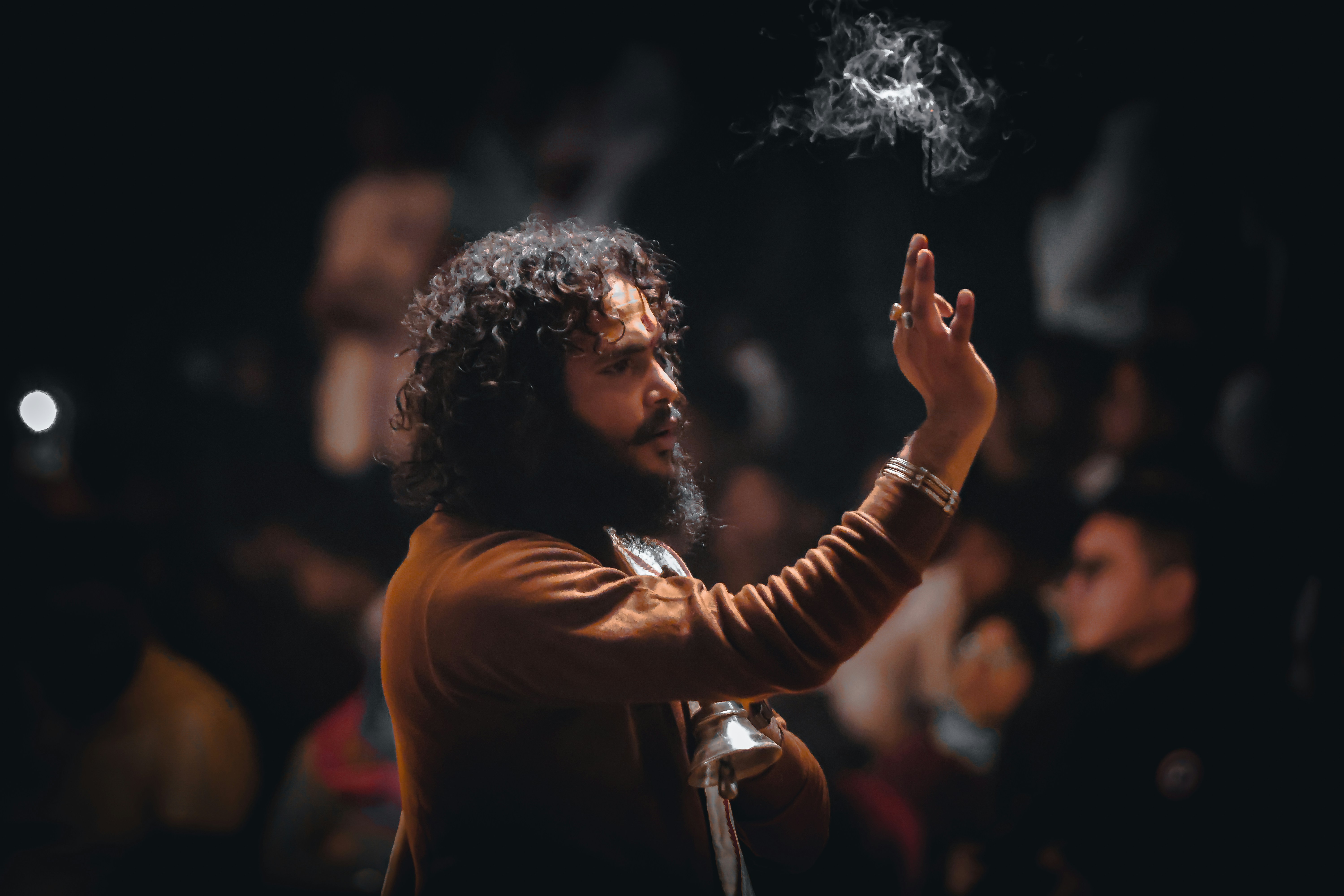Man with curly hair and smoke in the air.