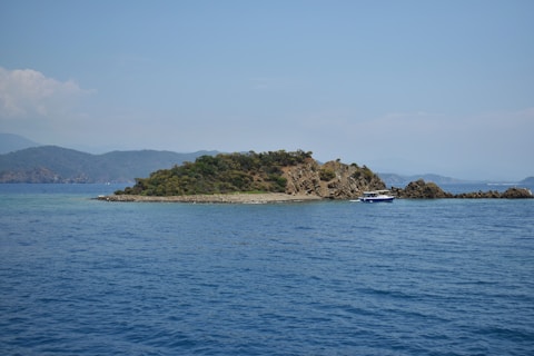 An island sits in the blue ocean waters.