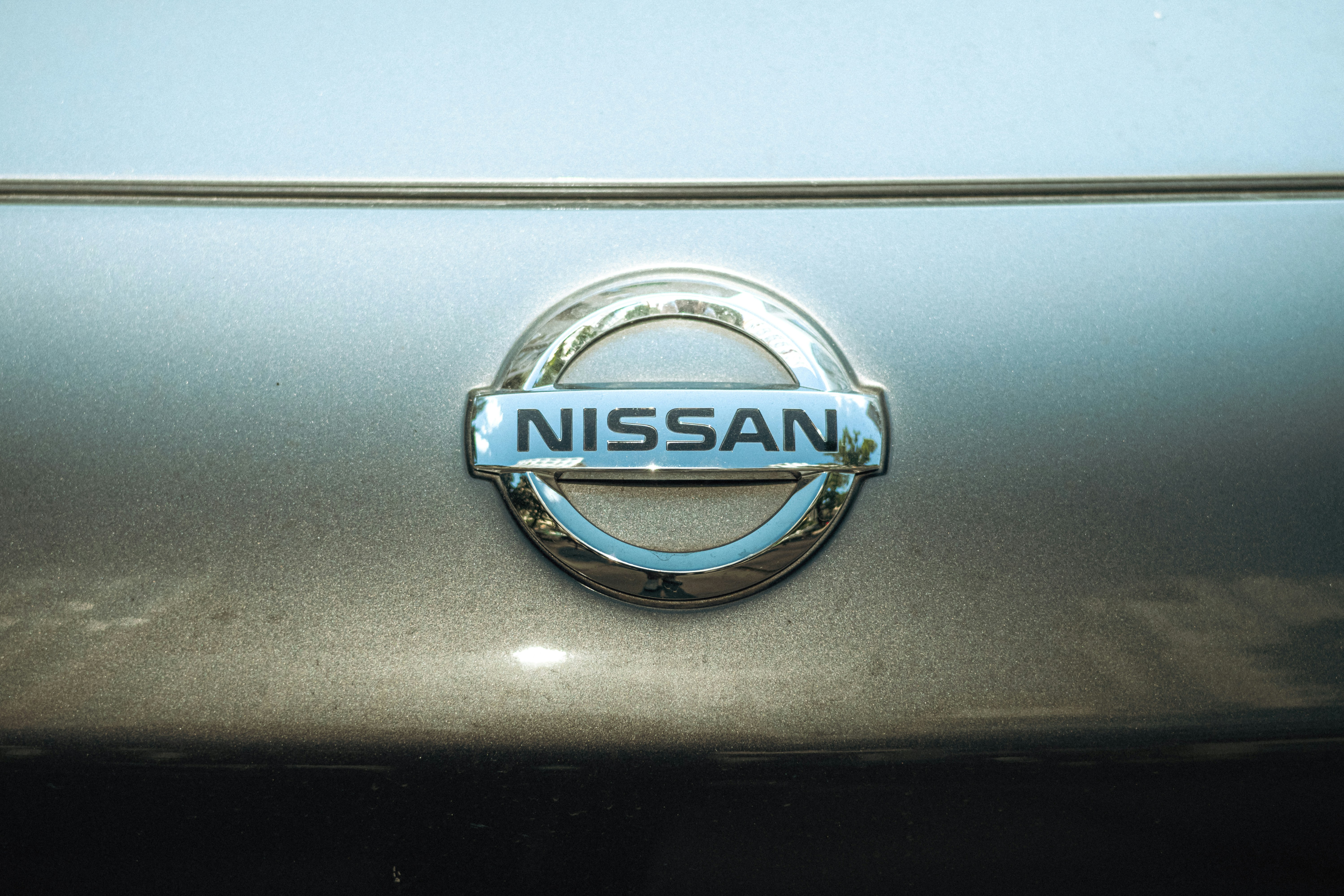 A close-up of the nissan logo.