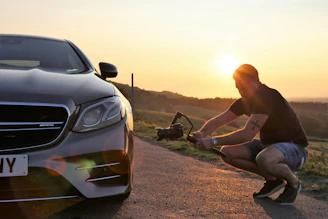 Photographer films car at sunset.