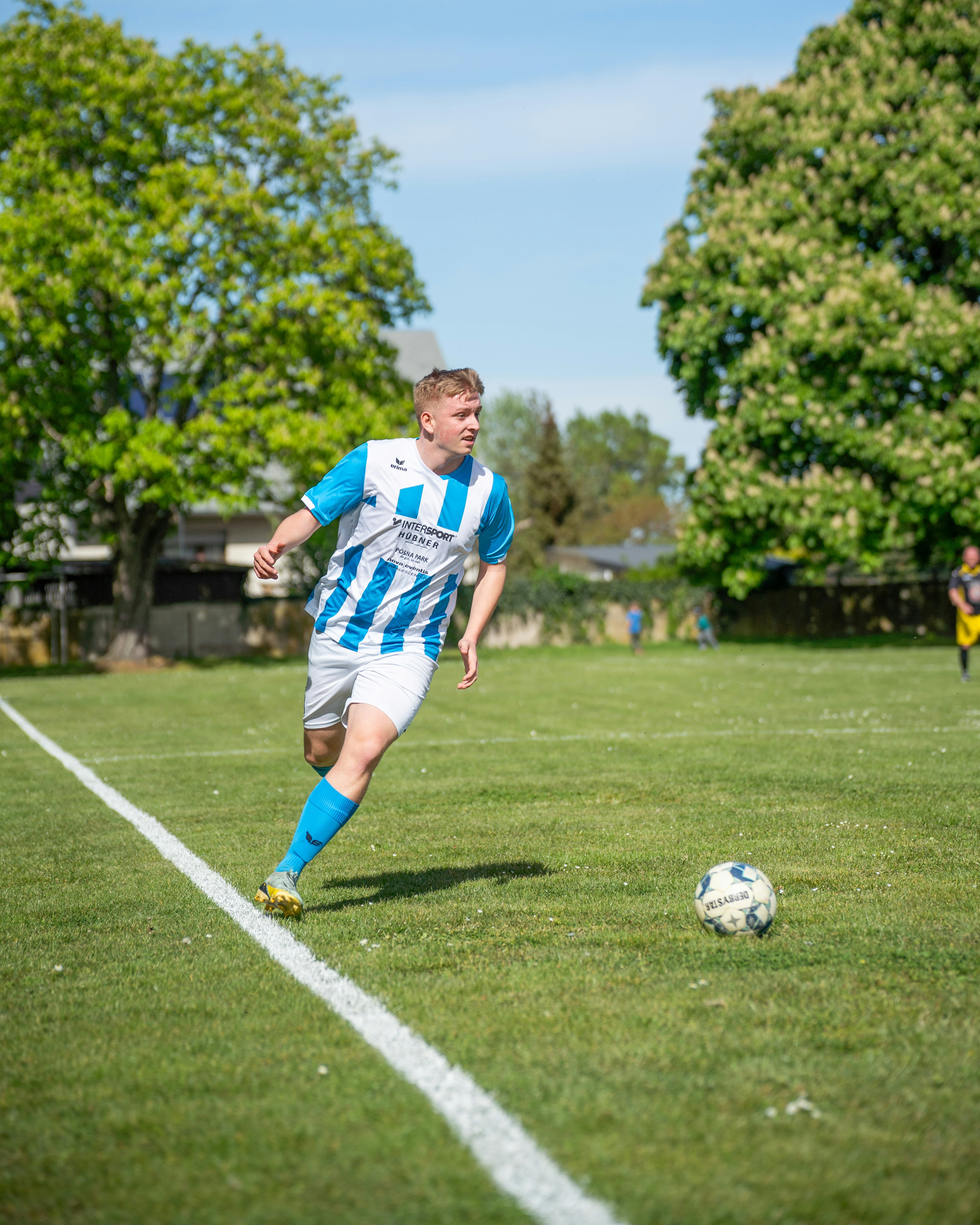 축구 선수가 경기장에 있는 공을 향해 달려갑니다.