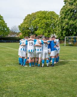 Soccer team huddled together on the field.