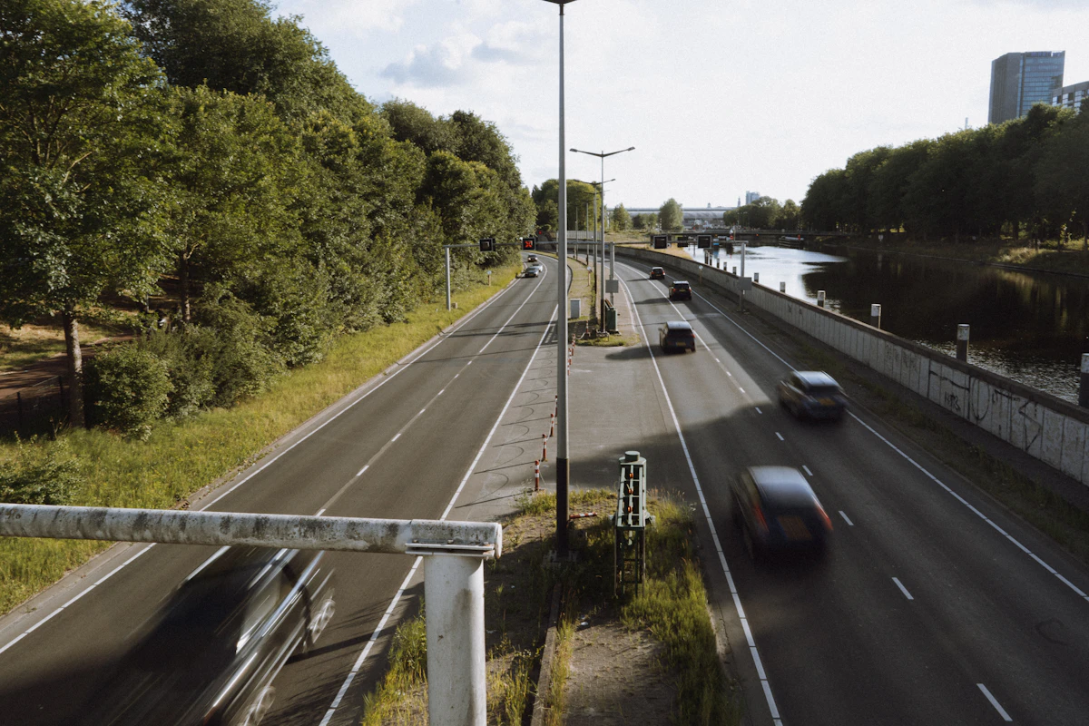 Voertuigen op een groene stadsroute langs een kanaal