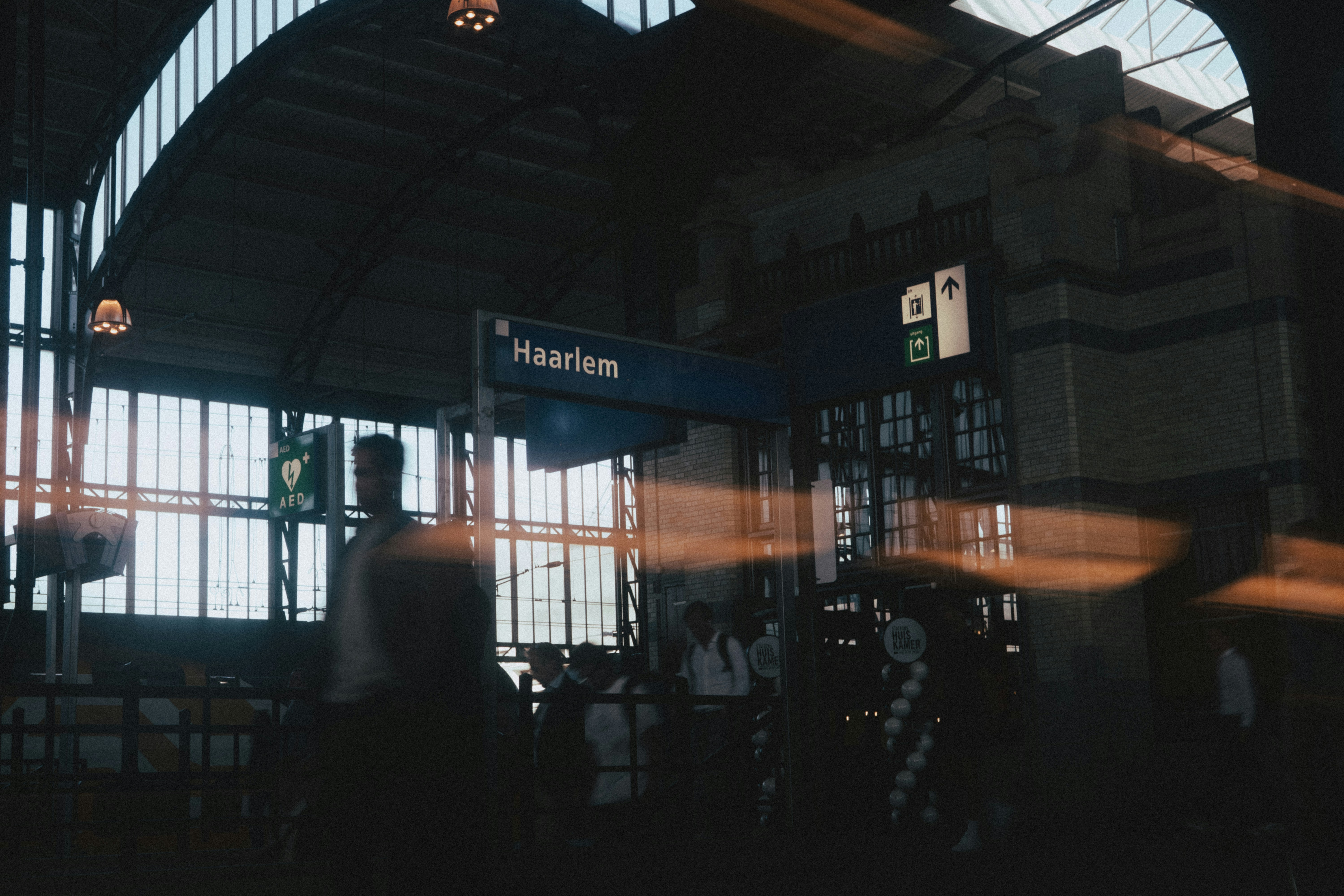People wait inside haarlem station.