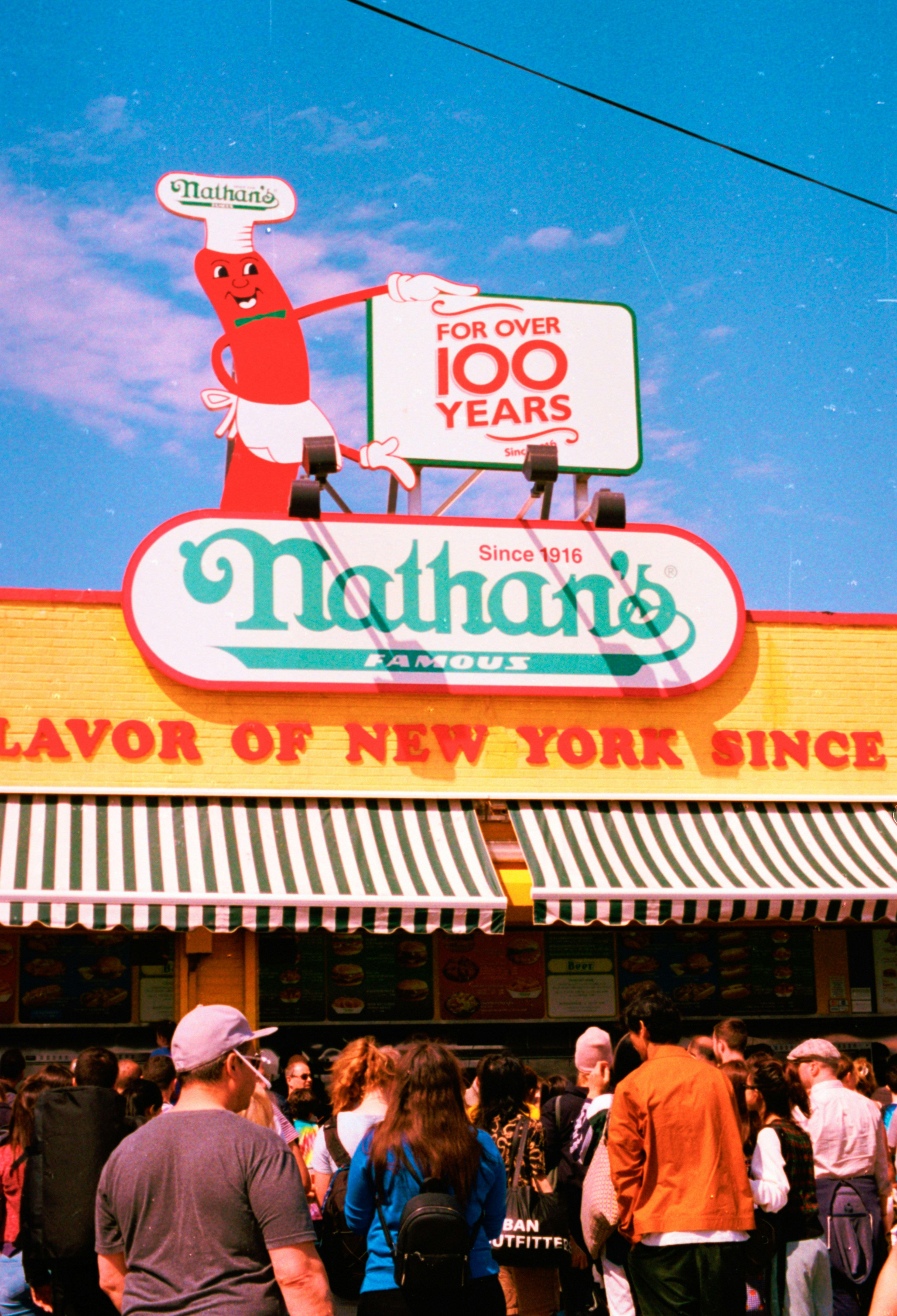 Nathan's famous hot dog stand with a crowd of people