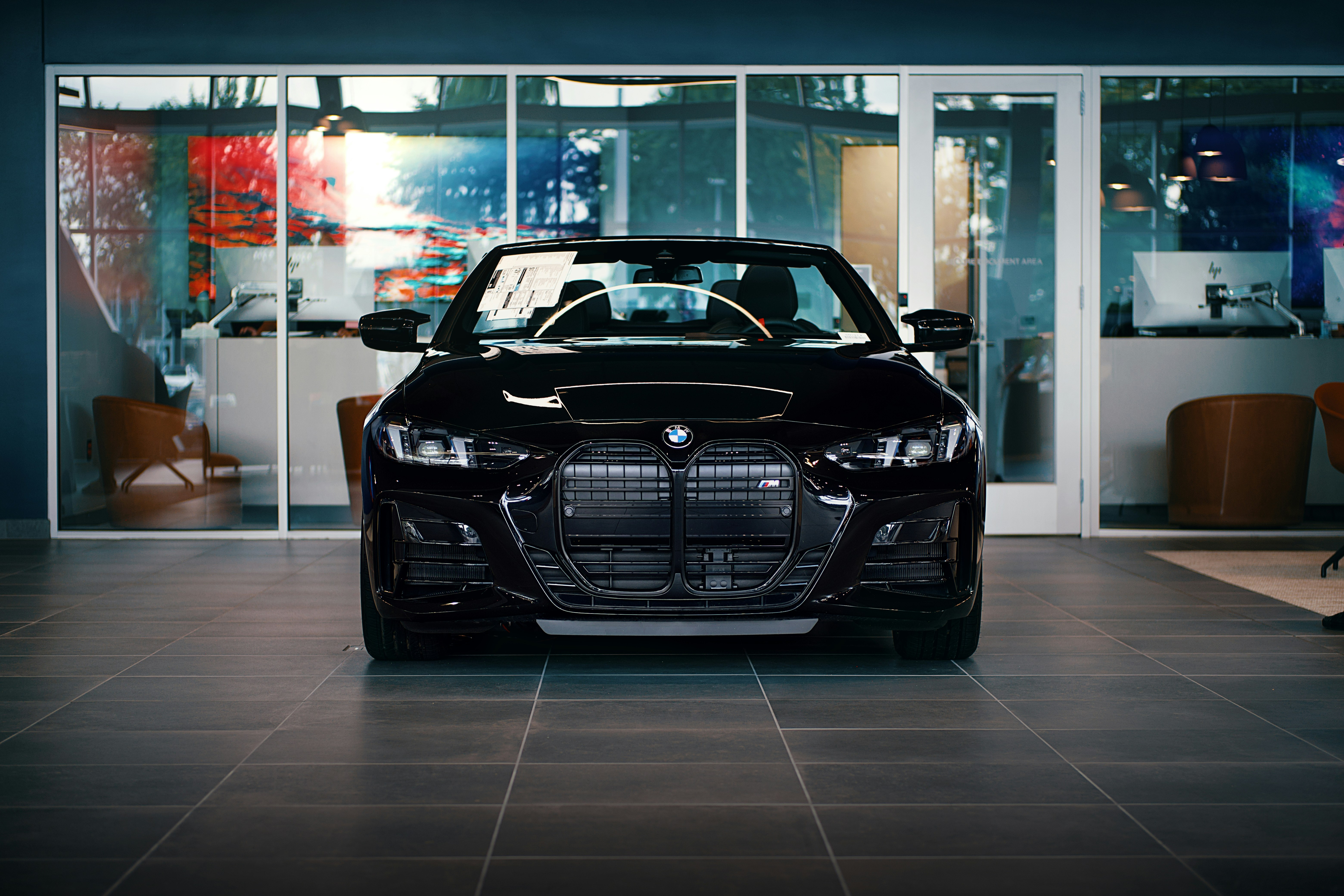 A black BMW car sits inside a showroom. photo – Free Car Image on Unsplash