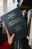 A hand holds a book about european union law