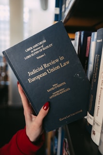 A hand holds a book about european union law.