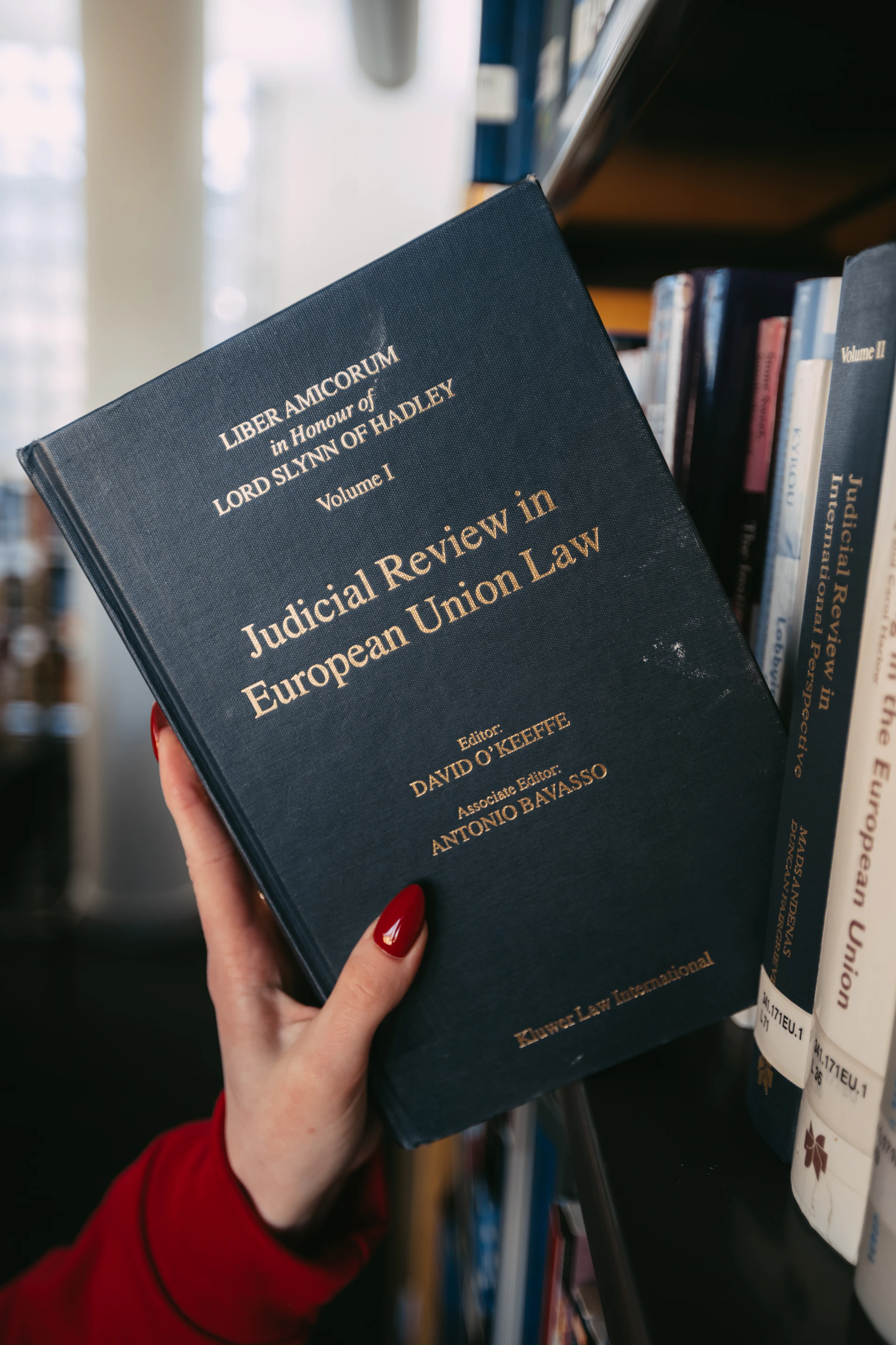 A hand holds a book about european union law.