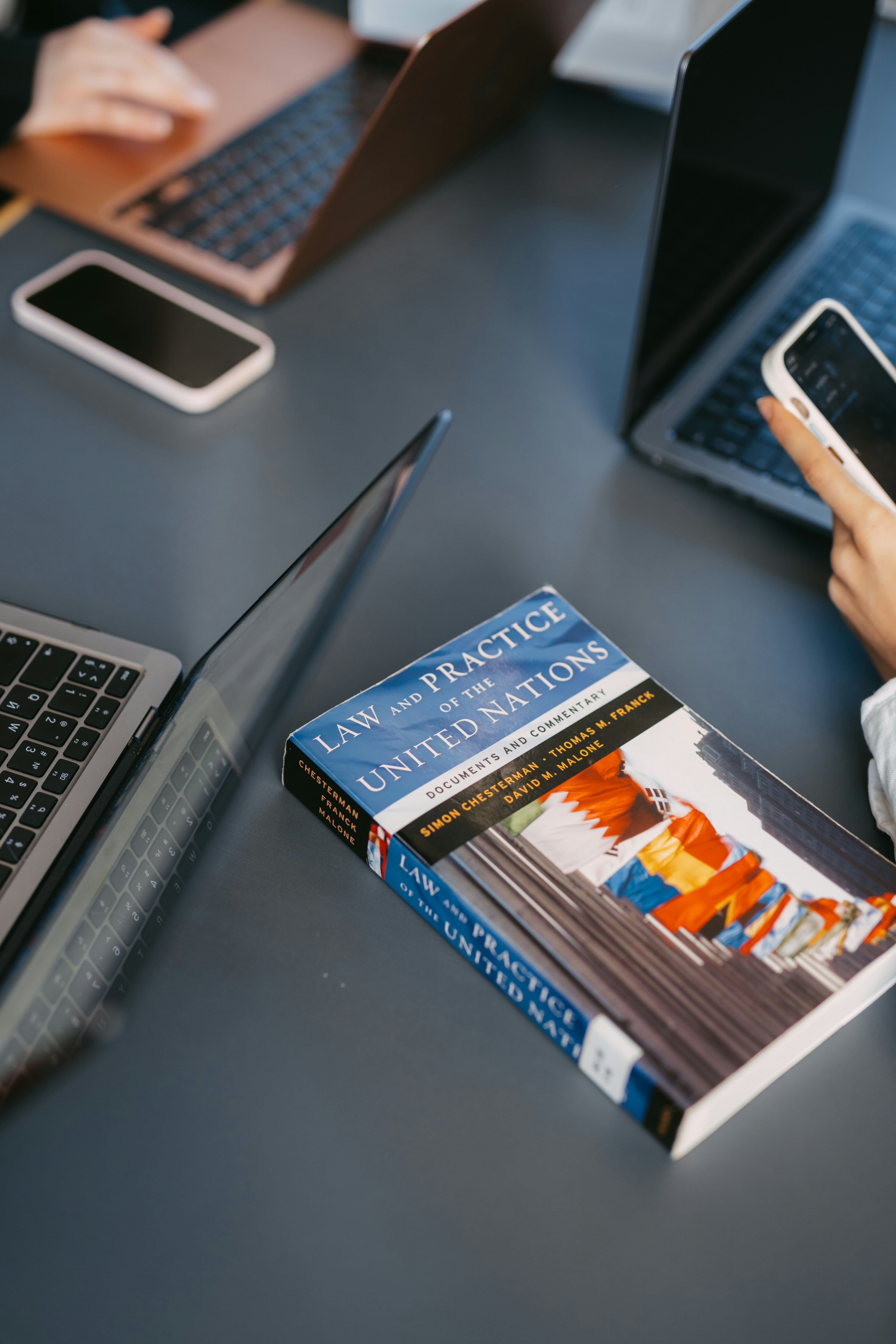 人々はラップトップと本を使って仕事をしています。