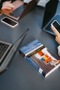 People are working with laptops and a book.
