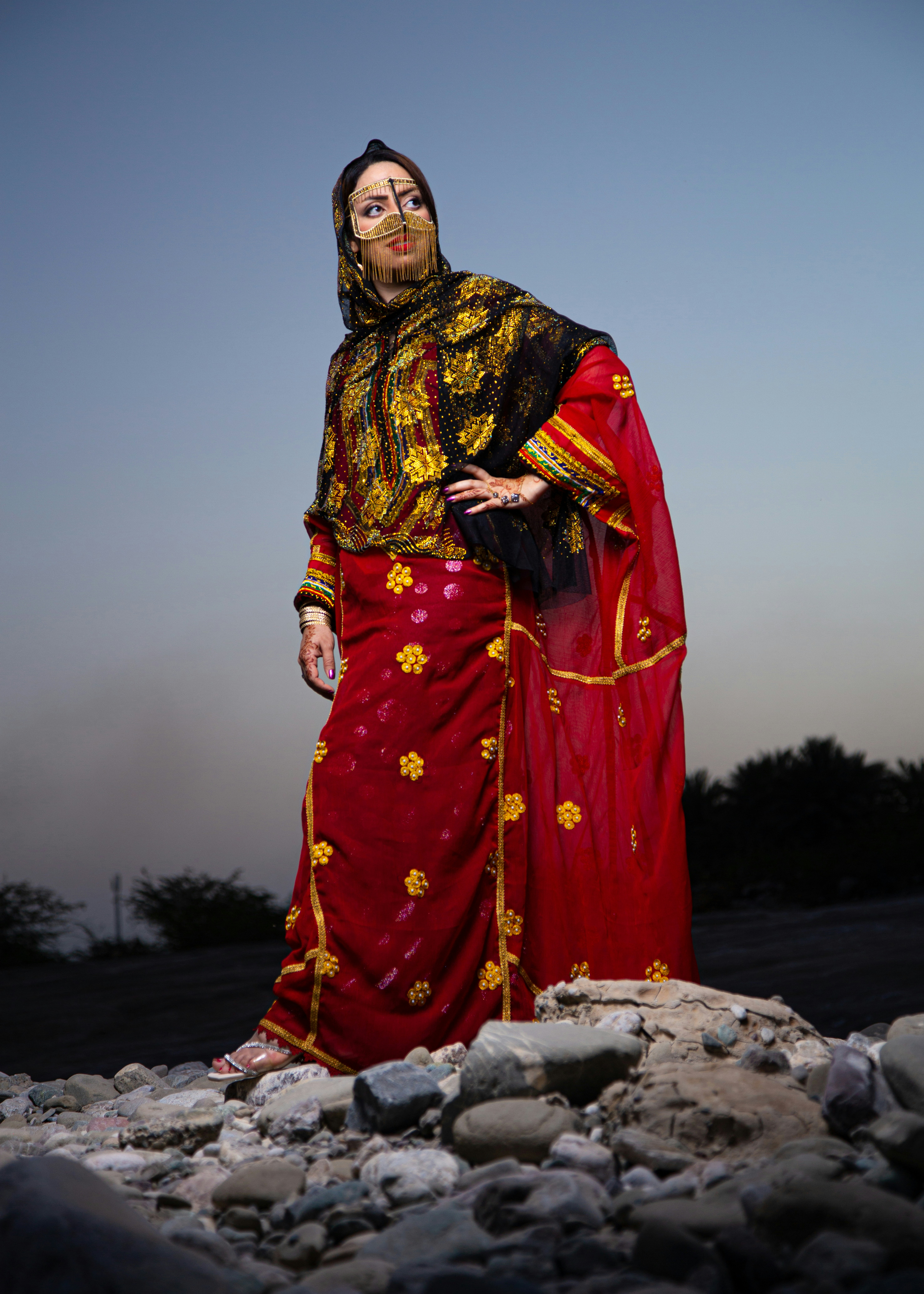 Woman poses in traditional attire with confident expression.