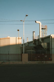 Factory exterior with smokestacks and utility poles.