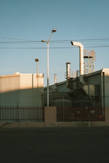 Factory exterior with smokestacks and utility poles.