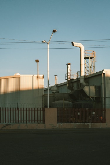 Factory exterior with smokestacks and utility poles.