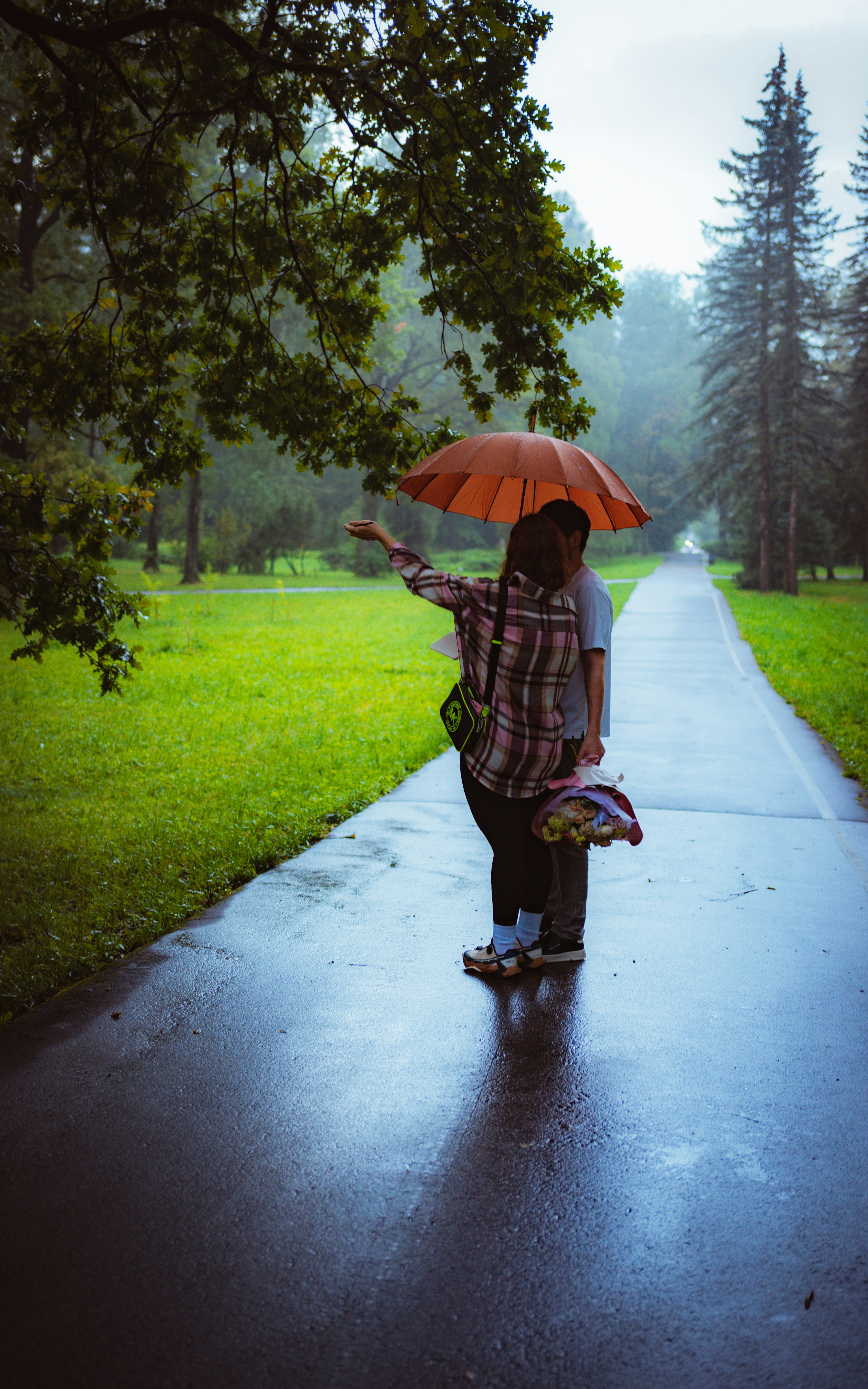 A couple shares an umbrella while walking.