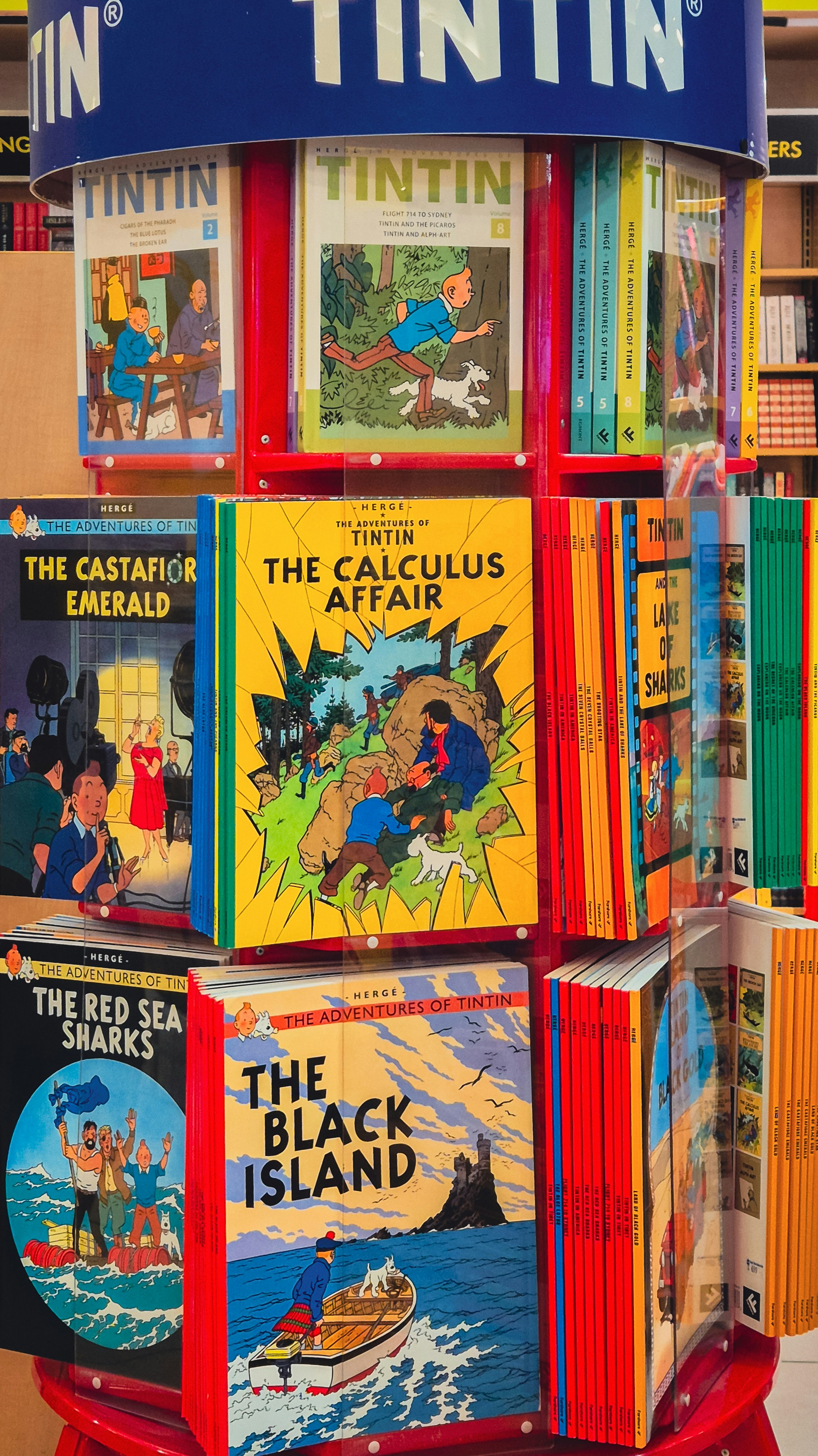 Tintin comic books are displayed on a circular rack.