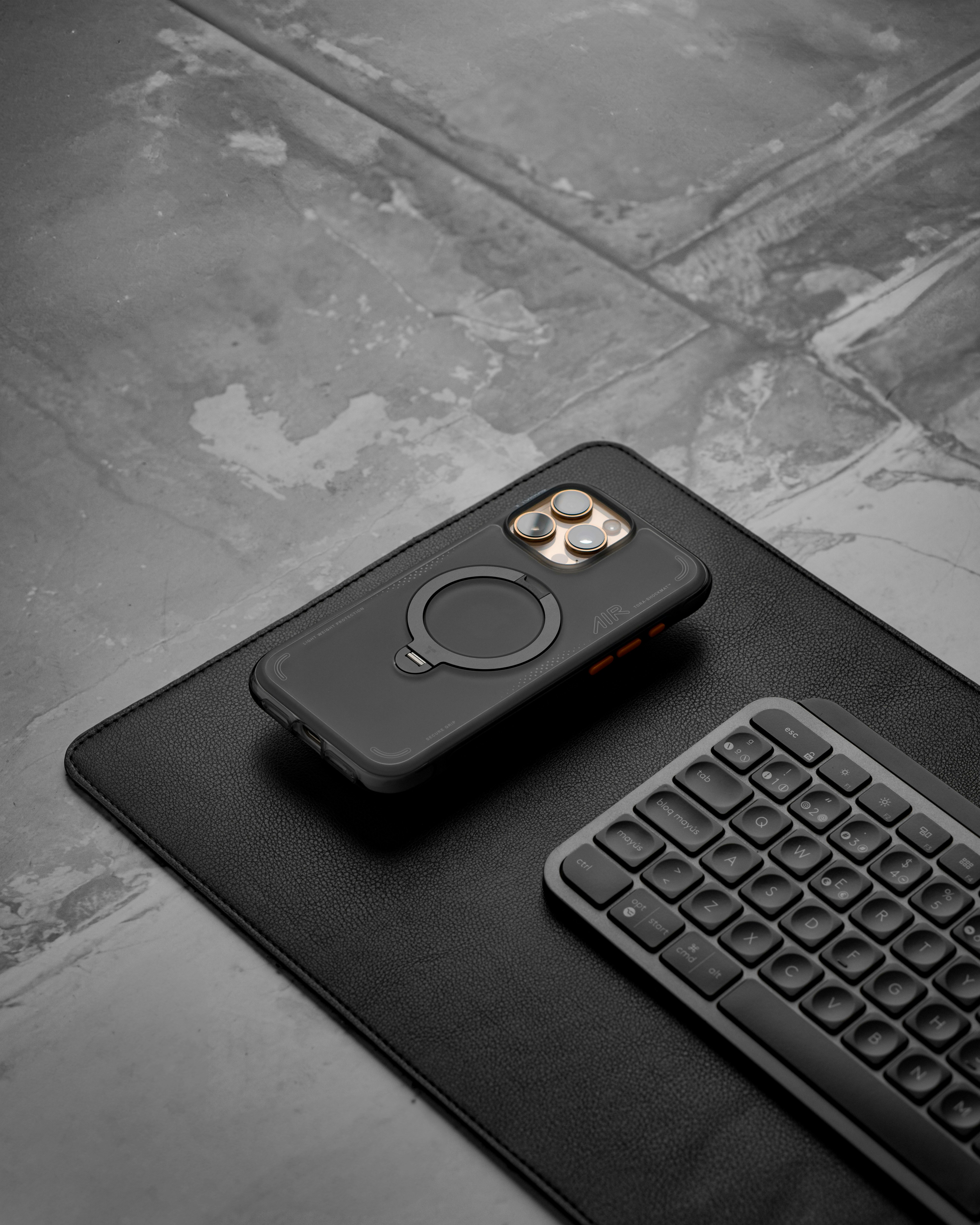 Smartphone, teclado e acessórios em uma mesa.