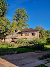 Old, crumbling building with overgrown vegetation.