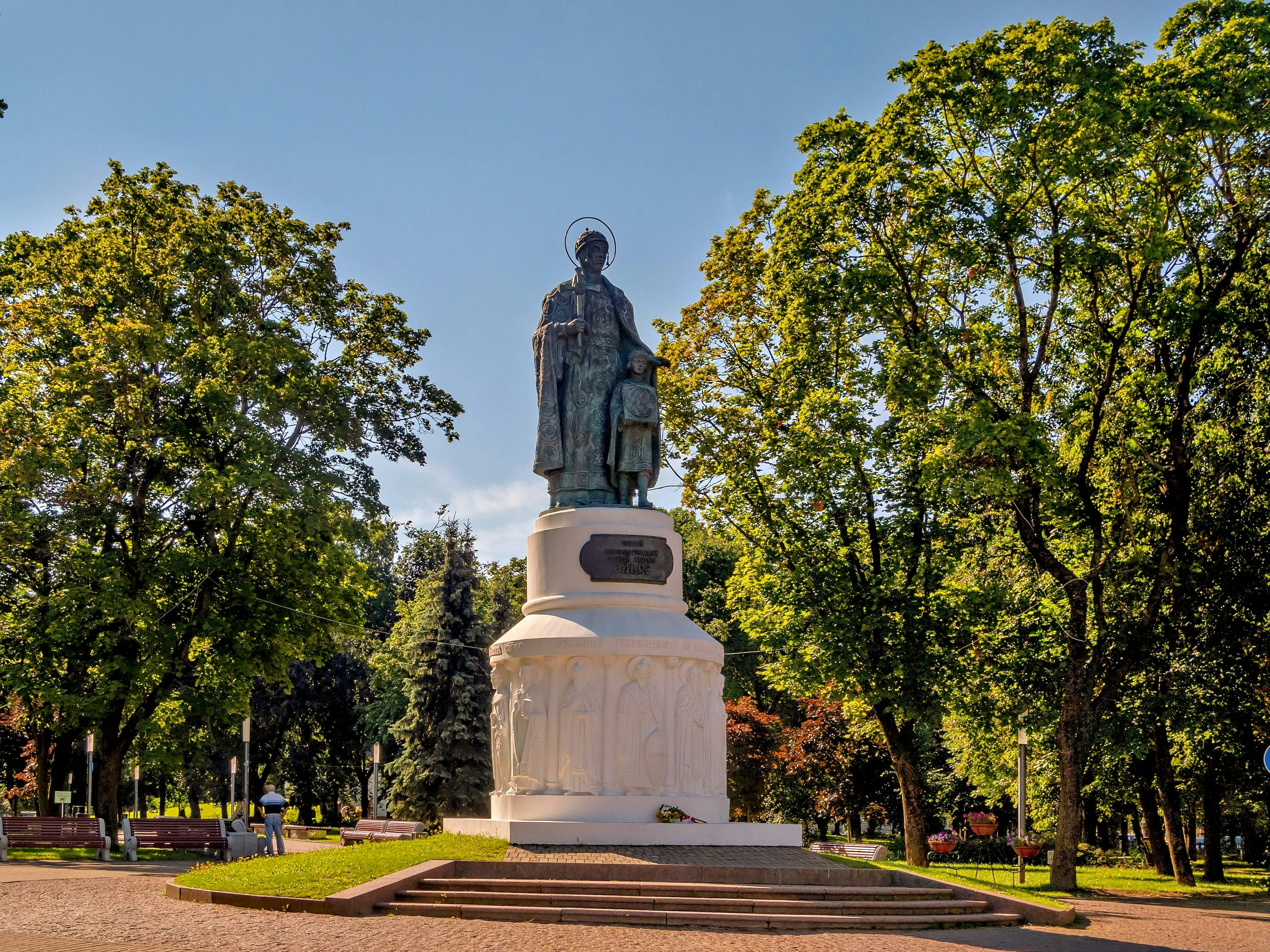 A statue stands proudly in a sunny park.