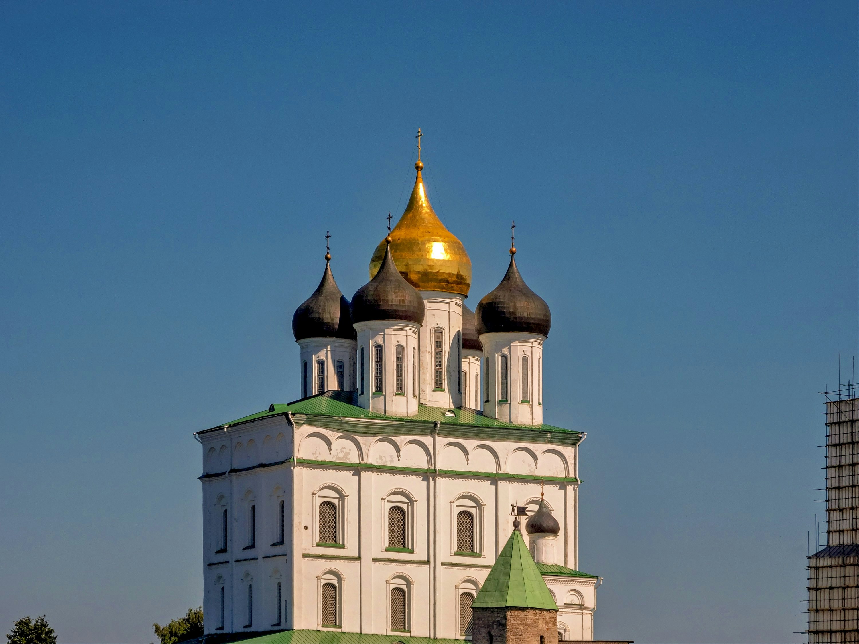 A golden-domed church stands against the clear blue sky.